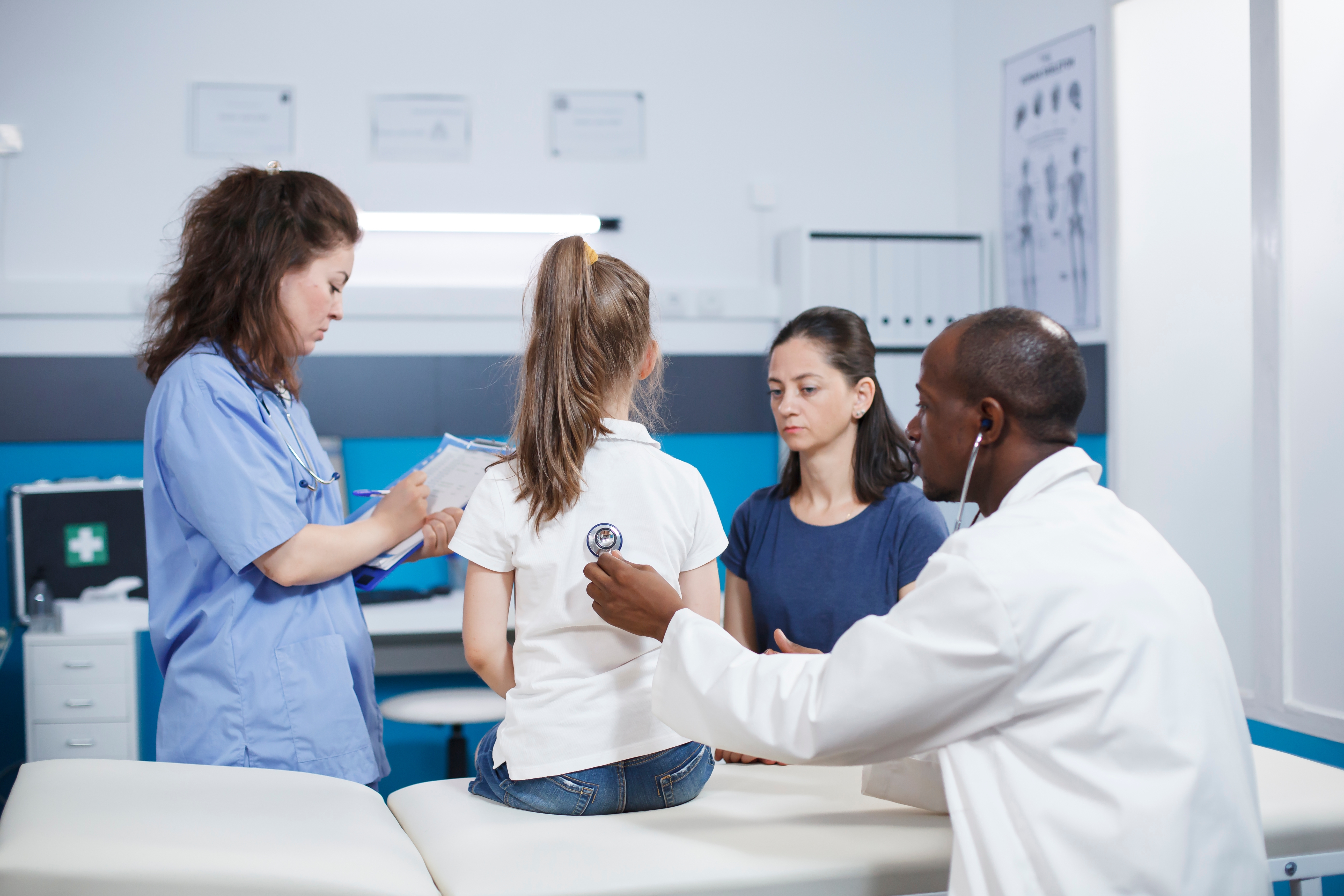 little girl getting checkup from doctor and staff