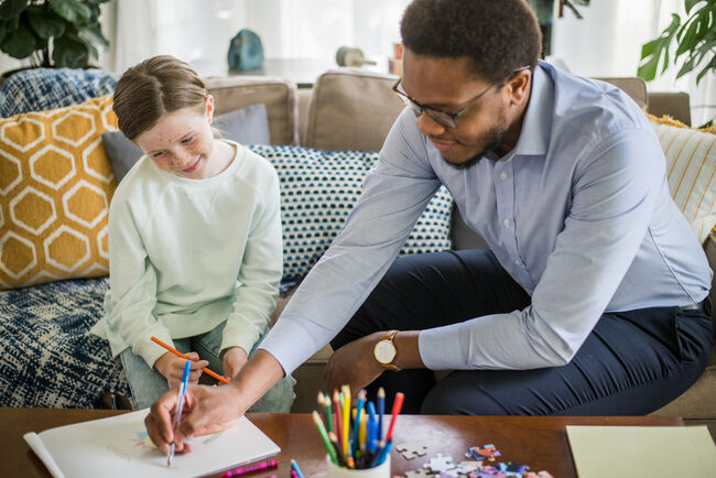 child social worker with girl coloring