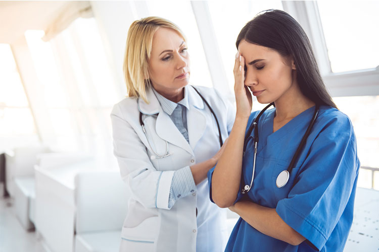 Doctor comporting a stressed nurse