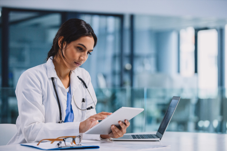 A medical professional looking at a tablet