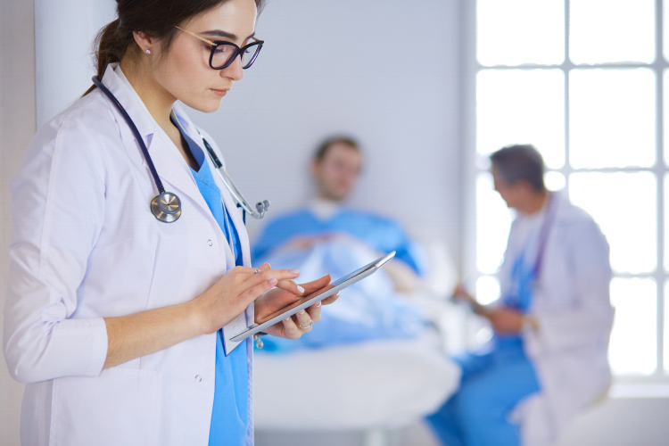 Nurse standing with a tablet.