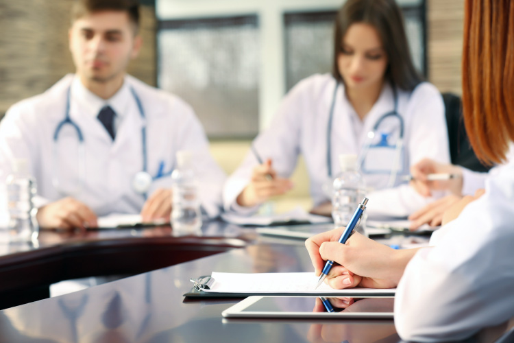  Nurses sitting around a table working. 