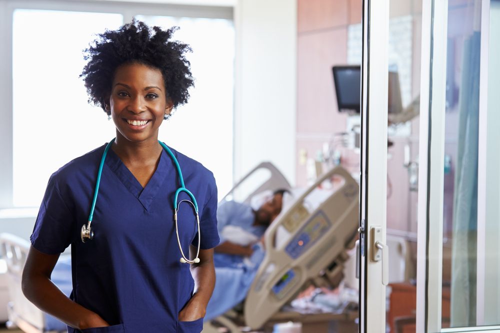Portrait of female nurse with patient in background