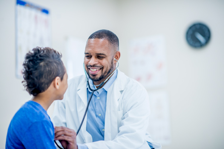 Black doctor examining a child 