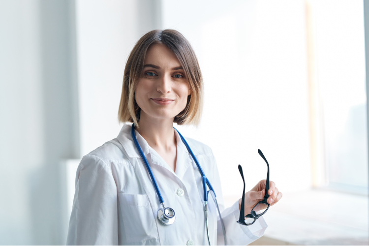 Nurse wearing a lab coat and smiling.