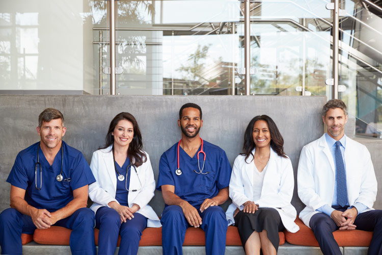 A group of medical professionals sitting together and smiling. 