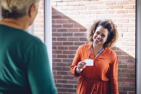 A smiling social worker conducts a home visit