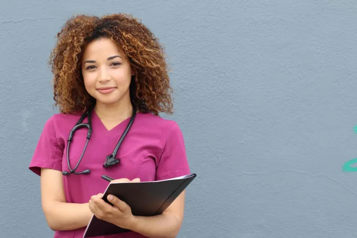 A smiling nurse holding a clipboard